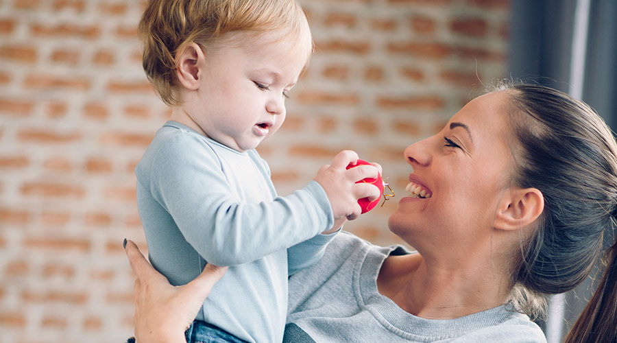 mother holding her baby smiling